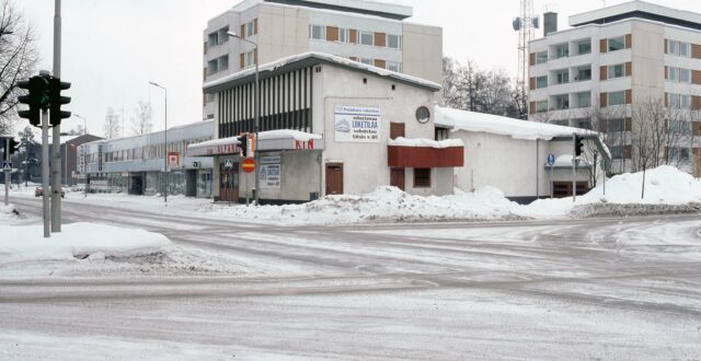 Talvinen näkymä Valtakadun ja Tunnelikadun kulmauksessa olevaan valkoiseen Kino Alfaromeon rakennukseen, jonka seinässä kyltti: Potinkara rakentaa / edustavaa liiketilaa valmistuu tähän v. 85. Rakennuksen edustalla lumikinoksia. Rakennuksen vieressä vasemmalla näkyy Hotelli Turistihovin rakennus Valtakatu 21, jonka eteen pysäköity kaksi henkilöautoa. Rakennusten takana näkyy kaksi kerrostaloa.